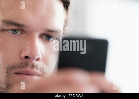 Close-up of mid-adult man texting Banque D'Images