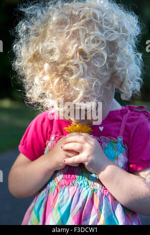 Portrait of young girl (4-5) smelling flower Banque D'Images