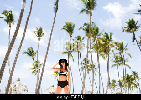 Woman on beach contre palmiers Banque D'Images