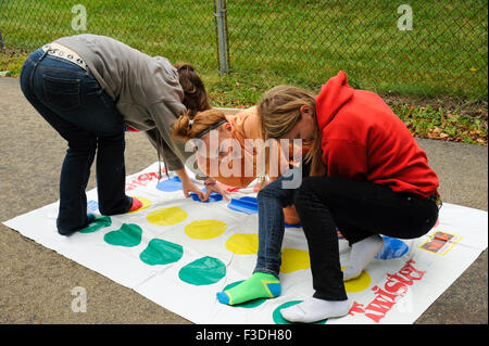 Ado et pré-ado filles jouer Twister Jeu de plancher. Banque D'Images