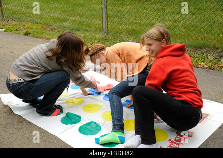 Ado et pré-ado filles jouer Twister Jeu de plancher. Banque D'Images