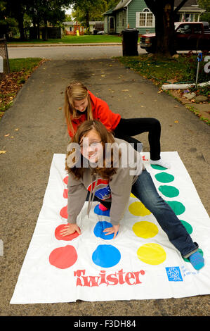 Ado et pré-ado filles jouer Twister Jeu de plancher. Banque D'Images