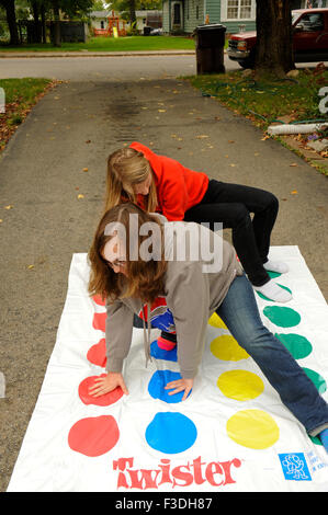 Ado et pré-ado filles jouer Twister Jeu de plancher. Banque D'Images