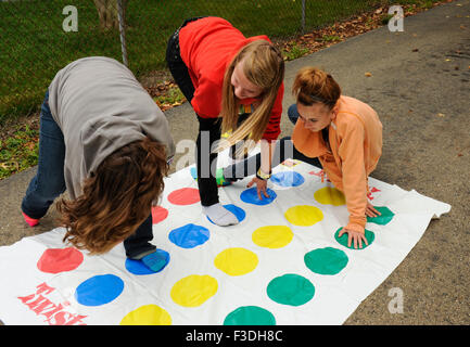 Ado et pré-ado filles jouer Twister Jeu de plancher. Banque D'Images