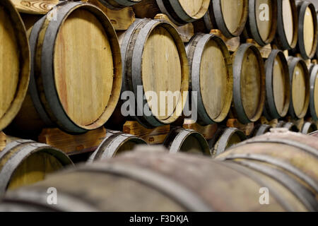 Détail tourné avec plusieurs tonneaux de vin en bois dans une cave Banque D'Images