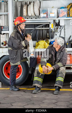 Les pompiers de discuter par camion à la caserne Banque D'Images