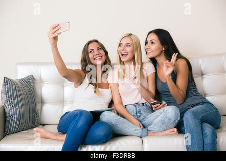 Portrait d'une des trois copines photo selfies sur smartphone à la maison Banque D'Images