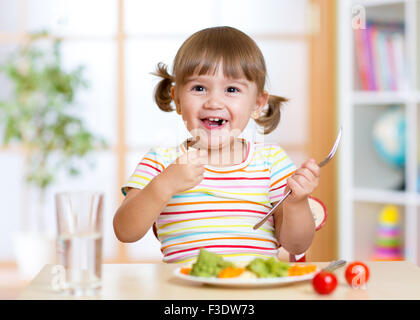 Kid girl eating légumes sains Banque D'Images