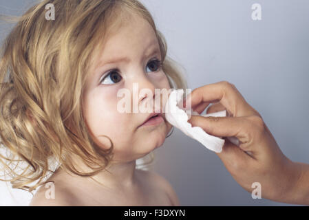 Essuyage Parent baby girl's face, portrait Banque D'Images