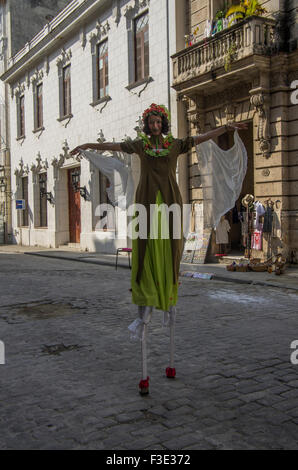 Artiste de rue en costume avec maquillage visage et robe verte, sur pilotis dans la vieille ville de La Havane, sur l'île de Cuba Banque D'Images