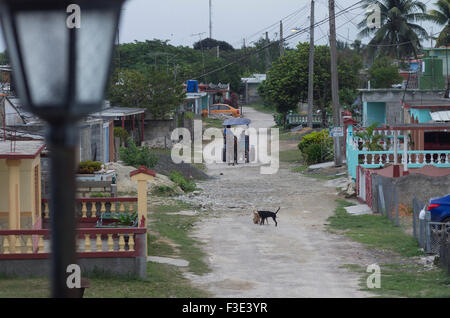 Les hommes Vente de pain sur un chemin de terre passe si la plage village de Playa Larga sur l'île de Cuba Banque D'Images