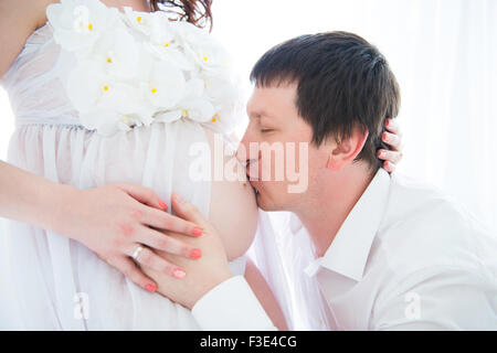 Mari accolades et embrassades pregnant belly de sa femme, close-up portrait Banque D'Images