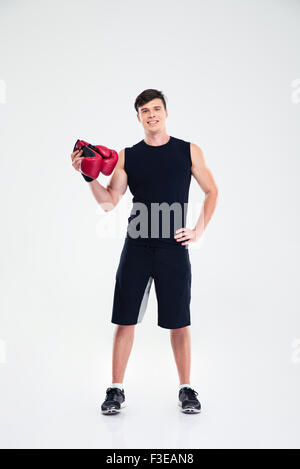 Portrait d'un homme tenant fitness gants boing isolé sur un fond blanc, looking at camera Banque D'Images