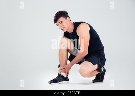Portrait de l'homme sportif souffrant de douleur dans la jambe isolé sur fond blanc Banque D'Images