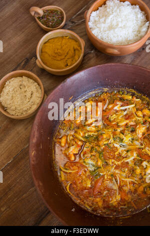 Brésil, Bahia. Moqueca - un ragoût de poissons ou de crevettes, d'huile de palme de dende, de lait de coco, de tomate, d'oignon et de coriandre. Servi avec de la pâte vatapa et des condiments Banque D'Images