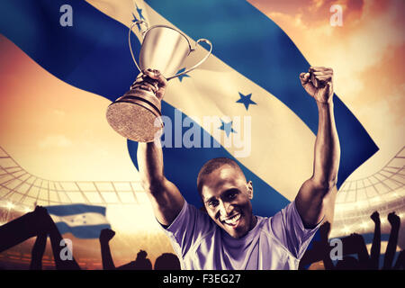 Image composite de portrait of happy sportsman acclamations tandis que holding trophy Banque D'Images