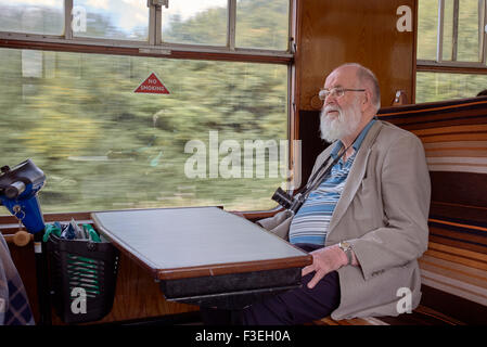 Senior citizen à bord du train à vapeur GWR vintage préservé qui voyagent à travers la campagne anglaise. England UK. Banque D'Images