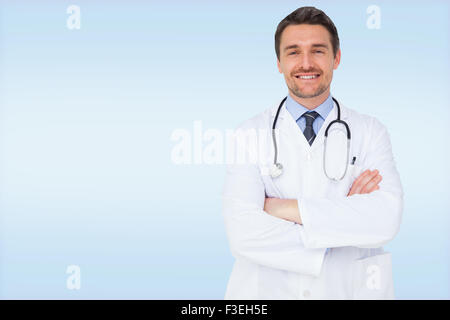 Image composite de handsome young doctor with arms crossed Banque D'Images