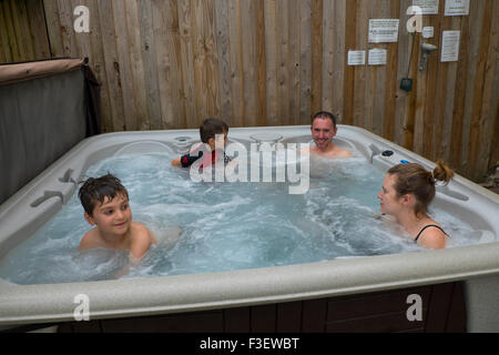 Détente en famille dans l'eau chaude à remous, Herefordshire, Angleterre, RU Banque D'Images