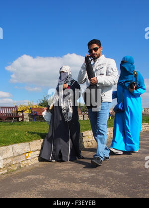 Un homme musulman dans les vêtements occidentaux et deux femmes portant des Niqabs traditionnels Banque D'Images