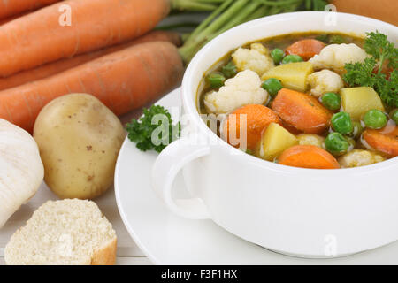 Gros plan de repas Soupe aux légumes avec les légumes, pommes de terre, les carottes et les petits pois dans un bol Banque D'Images
