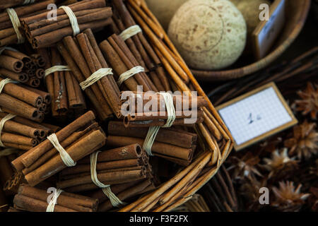 Tas de bâtons de cannelle en bottes liées avec de la ficelle dans une boîte en osier. Banque D'Images