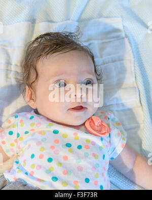 Un bébé de trois mois Caucasian girl avec les cheveux foncés et les yeux bleus. Libre. Banque D'Images