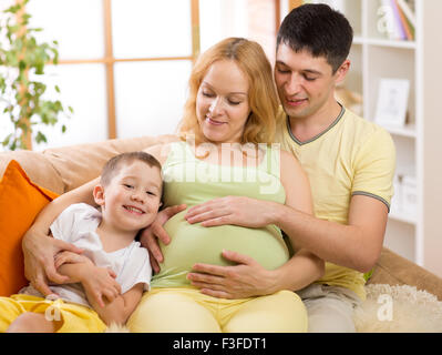 Attend de la famille nouveau bébé. Petit garçon et son père embrasser mère enceinte Banque D'Images