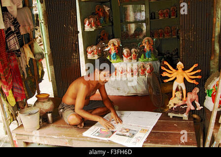 Kumartuli Durga Idol bouilloire reading Newspaper Calcutta vie à Calcutta ; l'ouest du Bengale en Inde ; Banque D'Images