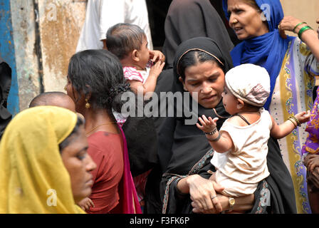 Les femmes musulmanes se tenir dans une file d'attente avec leurs enfants à un pouls d'entraînement de la poliomyélite à Baiganwadi Govandi ; Mumbai Maharashtra ; Banque D'Images