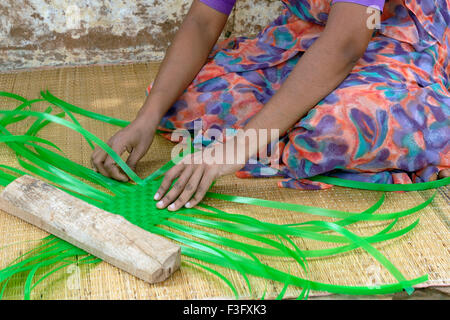 L'industrie familiale ; Femme tissant des bandes en plastique ; paniers ; Tamil Nadu Inde Banque D'Images