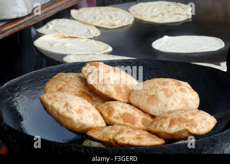 Fast food indien puri dans l'huile de friture faites maida en arrière-plan de la farine dans une poêle rôti roti ; Bombay Mumbai, Maharashtra Banque D'Images