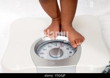 Bébé debout sur la machine pesant sept kilogrammes de poids - M.# 152 smr - 146938 Banque D'Images