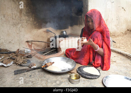 Une femme faisant du pain de blé ou rotis sur une cheminée ; Rajasthan Inde ; Banque D'Images