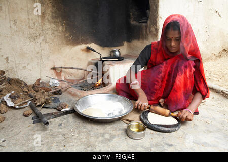 Femme indienne faisant du pain de blé ou de la rotis en roulant sur cheminée ouverte , Rajasthan , Inde Banque D'Images