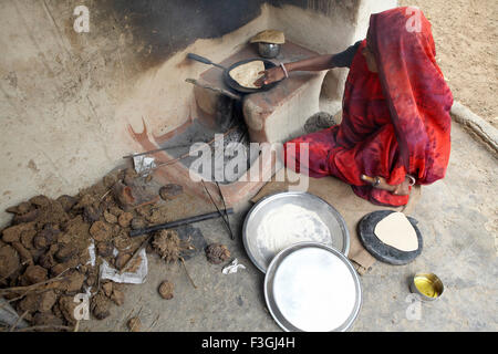 Une femme faisant du pain de blé ou rotis sur une cheminée ; Rajasthan Inde ; Banque D'Images