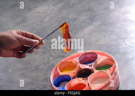 L'art persan Rogan artisanat peinture sur tissu de la couleur naturelle de l'huile de ricin peinture pigment coller sur l'axe métallique pinceau Nirona Kutch Gujarat Inde Banque D'Images