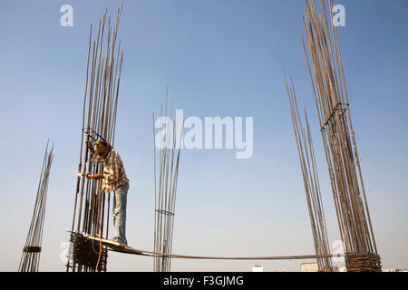 Un soudeur précairement debout sans un casque ou une ceinture de sécurité sur un chantier de construction ; Ahmedabad Gujarat ; Inde ; Banque D'Images