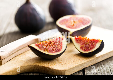 Figues fraîches en tranches sur une planche à découper Banque D'Images