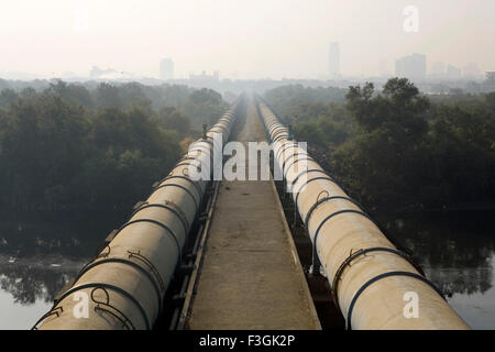 Des tuyaux d'eau vers le sud de Mumbai passent par Dharavi drapé dans le smog, Bombay, Mumbai, Maharashtra, Inde, Asie, Indien, asiatique Banque D'Images