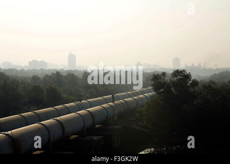 Des tuyaux d'eau vers le sud de Mumbai traversent Dharavi drapé dans le smog, Bombay, Mumbai, Maharashtra, Inde, Asie Banque D'Images