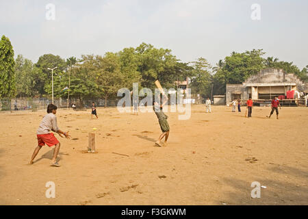 Des enfants qui jouent un jeu de cricket dans une communauté ouverte, la masse dans un bidonville ; Khotwadi ; Santacruz Bombay Mumbai Maharashtra ; Banque D'Images