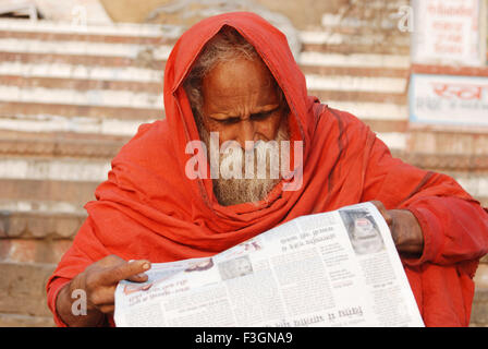 Journal de lecture Sadhu à ghat de Ganga ; Varanasi Uttar Pradesh ; Inde ; Banque D'Images