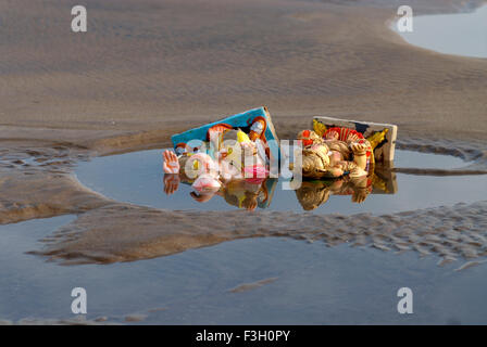 Idoles Ganesh couché dans l'eau polluée après immersion sur Aksa beach ; Bombay Mumbai Maharashtra ; Inde ; Banque D'Images