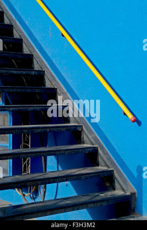 Escalier noir d'un bâtiment avec des murs bleus et un garde-corps jaune au Gujarat ; Inde ; Rajkot Banque D'Images