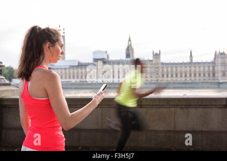 Formateur femelle mâle distribution runner sur Southbank, Londres, UK Banque D'Images