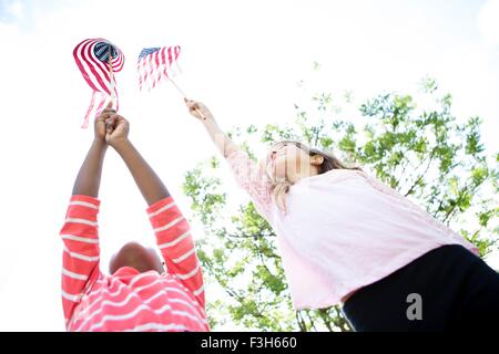 Girls holding up American flags in park Banque D'Images