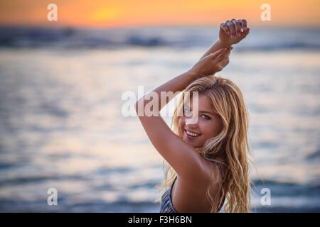 Portrait of young woman on beach at sunset Banque D'Images