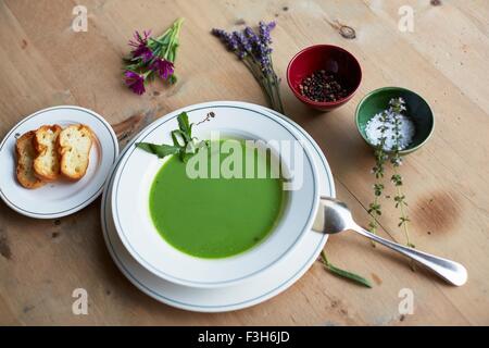 Table avec soupe verte et du pain frais Banque D'Images