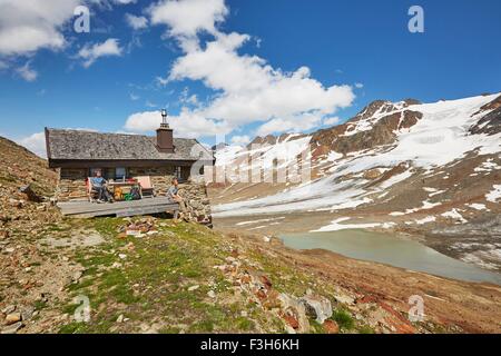 Jeune couple de randonnée en faisant une pause à l'extérieur de hut, Val Senales Val Senales, Glacier, Tyrol du Sud, Italie Banque D'Images